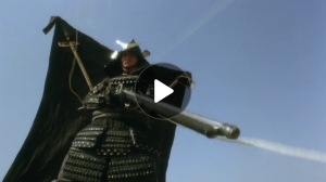 Screenshot with play button of a film clip of a warrior in battle.