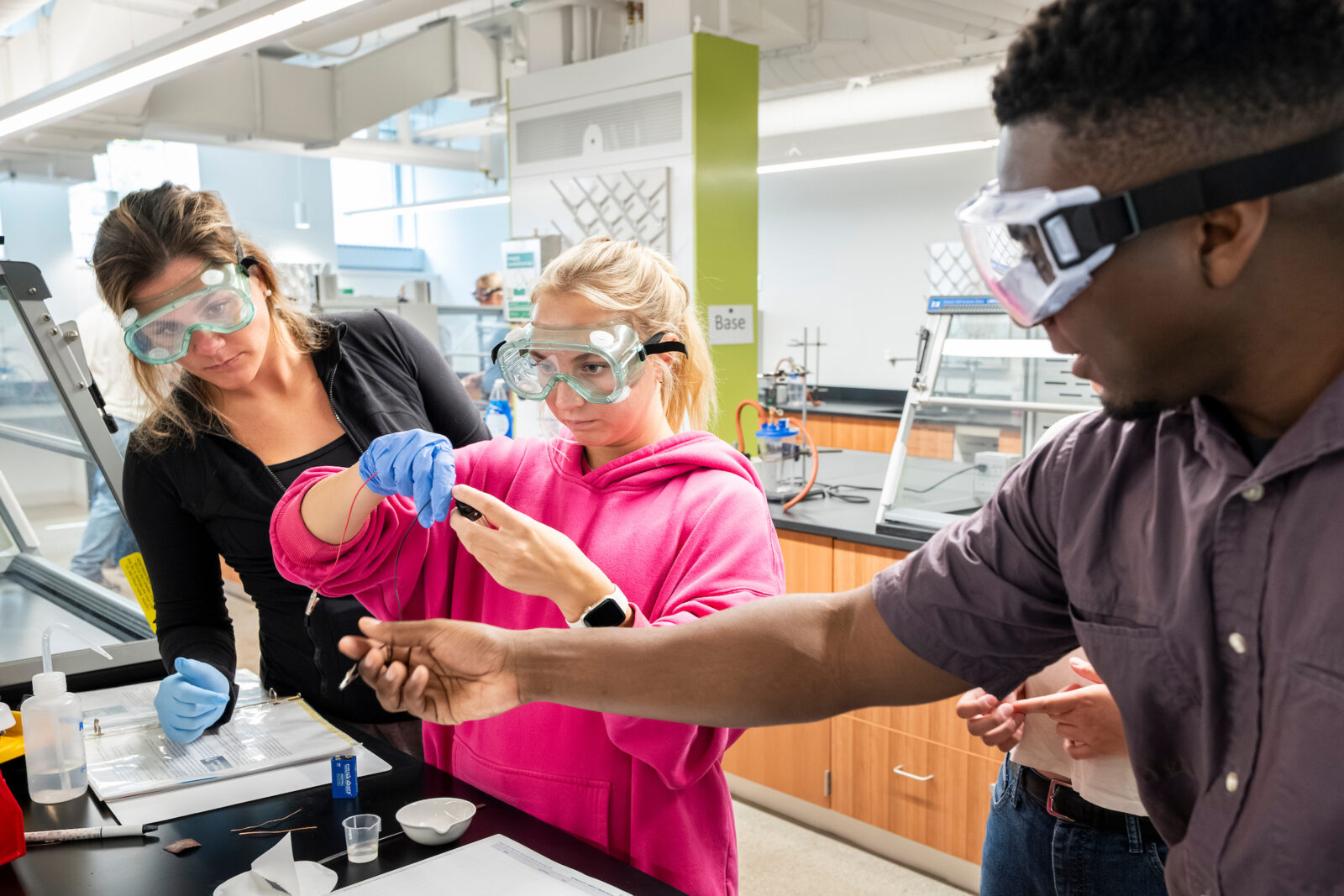 A TA observes two students doing an experiment during a chemistry lab.