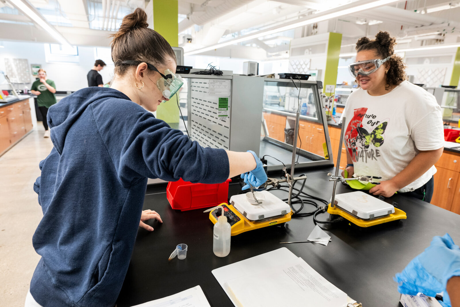 A TA observes a student conducting an experiment during a chemistry lab.